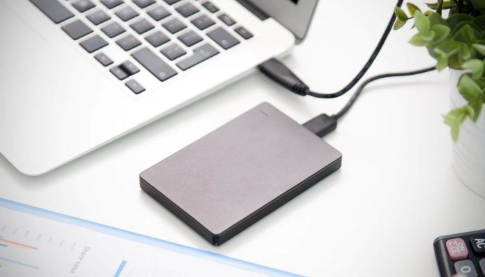 External backup disk hard drive connected to laptop. hard drive backup disk external computer data usb concept